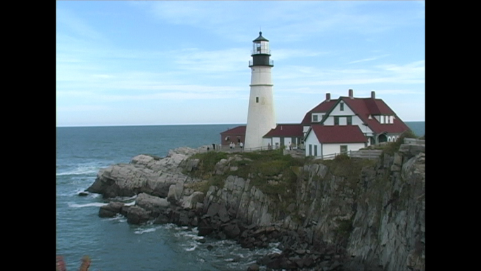 White Lighthouse on Tip of Rocky Shore